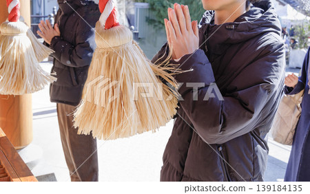 神社的鐘繩和雙手合十祈禱的人們:這是為新年和考試成功祈禱的場景。 神社的鐘繩和雙手合十祈禱的人們:這是為新年和考試成功祈禱的場景。 139184135