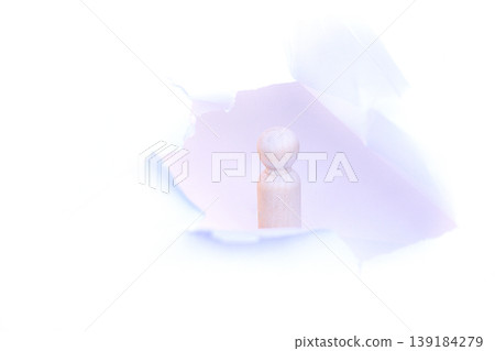 Wooden figurine standing upright in a torn white paper background, showcasing a minimalist design with soft lighting emphasizing the texture and shape of the figure Wooden figurine standing upright in a torn white paper background, showcasing a minimalist design with soft lighting emphasizing the texture and shape of the figure 139184279