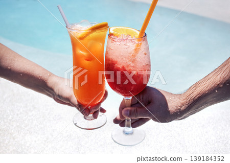Male and female hands hold out glasses with tasty cocktails for a toast Male and female hands hold out glasses with tasty cocktails for a toast 139184352