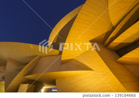 Doha, Qatar - Jan 06 2024, a bottom up view of National Museum of Qatar part of facade, exterior, in courtyard, patio shaped like a desert rose, at nighttime, with illumination, Doha, Qatar Doha, Qatar - Jan 06 2024, a bottom up view of National Museum of Qatar part of facade, exterior, in courtyard, patio shaped like a desert rose, at nighttime, with illumination, Doha, Qatar 139184668