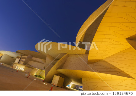 Doha, Qatar - Jan 06 2024, a bottom up view of National Museum of Qatar part of facade, exterior, in courtyard, patio shaped like a desert rose, at nighttime, with illumination, Doha, Qatar Doha, Qatar - Jan 06 2024, a bottom up view of National Museum of Qatar part of facade, exterior, in courtyard, patio shaped like a desert rose, at nighttime, with illumination, Doha, Qatar 139184670
