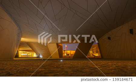 Doha, Qatar - Jan 06 2024, a panoramic view of wide passage with low ceiling, in National Museum of Qatar, in shape of desert rose, at nighttime, Doha, Qatar  139184671
