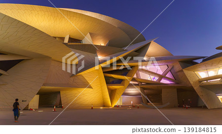 Doha, Qatar - Jan 06 2024, a bottom up view of National Museum of Qatar part of facade, exterior, in courtyard, patio shaped like a desert rose, at nighttime, with illumination, Doha, Qatar Doha, Qatar - Jan 06 2024, a bottom up view of National Museum of Qatar part of facade, exterior, in courtyard, patio shaped like a desert rose, at nighttime, with illumination, Doha, Qatar 139184815
