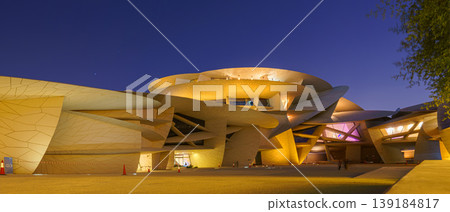 Doha, Qatar - Jan 06 2024, a bottom up view of National Museum of Qatar part of facade, exterior, in courtyard, patio shaped like a desert rose, at nighttime, with illumination, Doha, Qatar Doha, Qatar - Jan 06 2024, a bottom up view of National Museum of Qatar part of facade, exterior, in courtyard, patio shaped like a desert rose, at nighttime, with illumination, Doha, Qatar 139184817