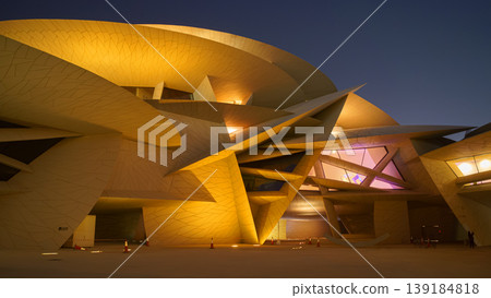 Doha, Qatar - Jan 06 2024, a bottom up view of National Museum of Qatar part of facade, exterior, in courtyard, patio shaped like a desert rose, at nighttime, with illumination, Doha, Qatar Doha, Qatar - Jan 06 2024, a bottom up view of National Museum of Qatar part of facade, exterior, in courtyard, patio shaped like a desert rose, at nighttime, with illumination, Doha, Qatar 139184818