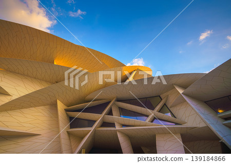 Doha, Qatar - Jan 06 2024, a panoramic view of National Museum of Qatar facade, exterior, shaped like a desert rose, at evening with blue sky, Doha, Qatar  139184866