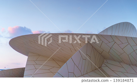 Doha, Qatar - Jan 06 2024, a close up view of part of facade of National Museum of Qatar, shaped like a desert rose, at evening with blue sky, Doha, Qatar Doha, Qatar - Jan 06 2024, a close up view of part of facade of National Museum of Qatar, shaped like a desert rose, at evening with blue sky, Doha, Qatar 139184871