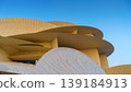 Doha, Qatar - Jan 06 2024, a panoramic view of National Museum of Qatar facade, exterior, shaped like a desert rose, at evening with blue sky, Doha, Qatar  139184913