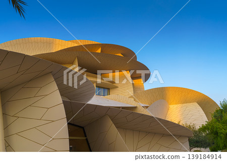 Doha, Qatar - Jan 06 2024, a panoramic view of National Museum of Qatar facade, exterior, shaped like a desert rose, at evening with blue sky, Doha, Qatar  139184914