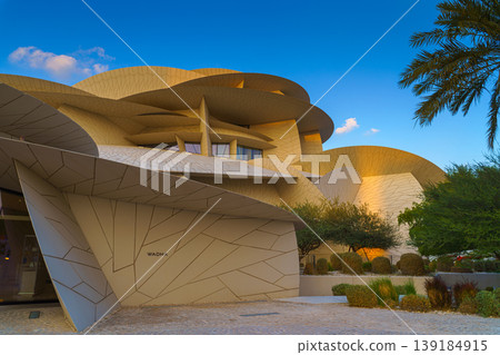 Doha, Qatar - Jan 06 2024, a panoramic view of National Museum of Qatar facade, exterior, shaped like a desert rose, at evening with blue sky, Doha, Qatar  139184915