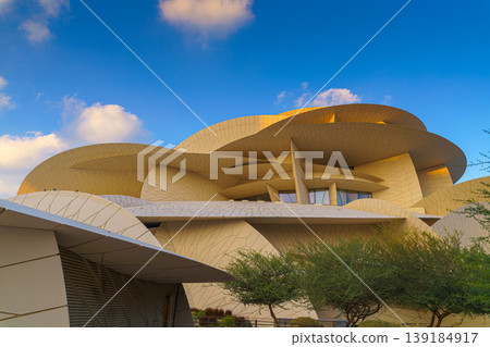 Doha, Qatar - Jan 06 2024, a panoramic view of National Museum of Qatar facade, exterior, shaped like a desert rose, at evening with blue sky, Doha, Qatar  139184917