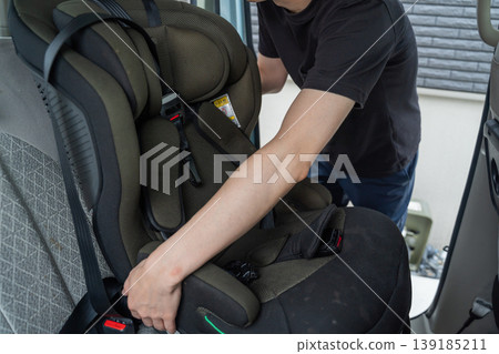 A man installing a child car seat A man installing a child car seat 139185211