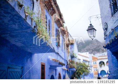 Vibrant blue alleyway with traditional architecture, adorned with greenery and a vintage lantern, creating a picturesque scene of cultural heritage and charm 139185295