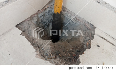Industrial Hole in Concrete Floor with Yellow Support Pillar Industrial Hole in Concrete Floor with Yellow Support Pillar 139185323