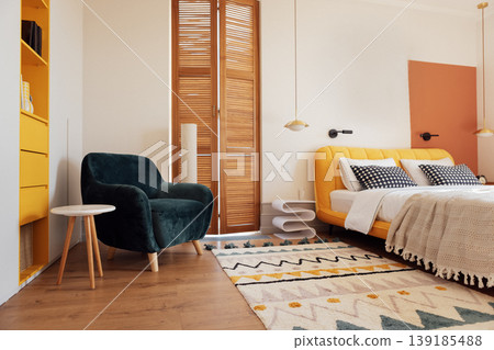 A modern bedroom with a comfortable bed and a bright yellow headboard A modern bedroom with a comfortable bed and a bright yellow headboard 139185488