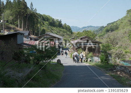 Hikers walking along the Nakasendo and Kiso Roads: Springtime scenery of historic roads leading to lush green mountain villages. Hikers walking along the Nakasendo and Kiso Roads: Springtime scenery of historic roads leading to lush green mountain villages. 139185629