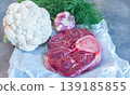 Raw beef shank steak meat with cauliflower garlic dill and cooking ingredients on paper. Rustic kitchen setup for homemade broth, soup and stew preparation. 139185855