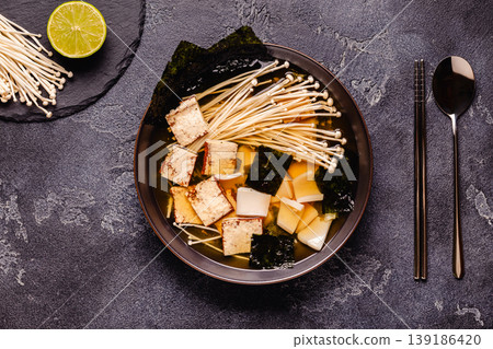 Asian-style soup with squid, tofu and enoki mushrooms. Asian-style soup with squid, tofu and enoki mushrooms. 139186420