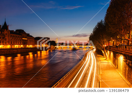 View of Paris by night with the Seine river and the Conciergerie building 139186479