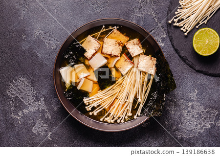 Asian-style soup with squid, tofu and enoki mushrooms. Asian-style soup with squid, tofu and enoki mushrooms. 139186638