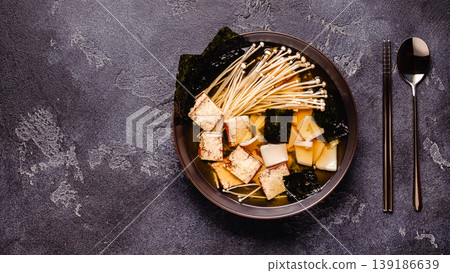 Asian-style soup with squid, tofu and enoki mushrooms. Asian-style soup with squid, tofu and enoki mushrooms. 139186639