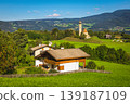 Typical scattered alpine village with cute church on the meadow 139187109