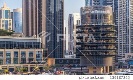 Aerial view of Dubai Marina with shopping mall, restaurants, towers and yachts timelapse, United Arab Emirates. Aerial view of Dubai Marina with shopping mall, restaurants, towers and yachts timelapse, United Arab Emirates. 139187263