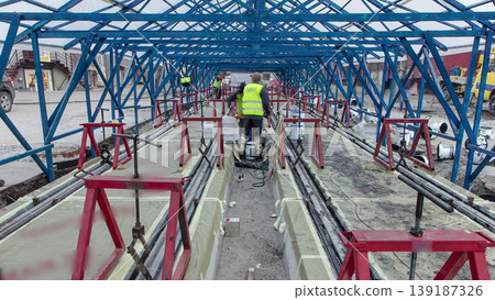 Tram rails at the stage of their installation and integration into concrete plates on the road timelapse. 139187326