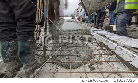 Pouring ready-mixed concrete after placing steel reinforcement to make the road by concrete mixer timelapse hyperlapse. Pouring ready-mixed concrete after placing steel reinforcement to make the road by concrete mixer timelapse hyperlapse. 139187329