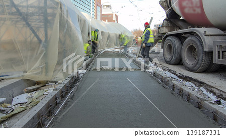 Pouring ready-mixed concrete after placing steel reinforcement to make the road by concrete mixer timelapse hyperlapse. 139187331