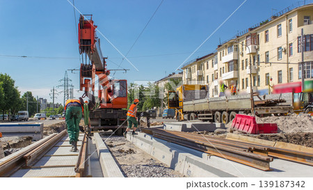 Orange construction telescopic mobile crane unloading tram rails from truck timelapse. Orange construction telescopic mobile crane unloading tram rails from truck timelapse. 139187342