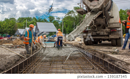 Concrete works for road construction with many workers and mixer timelapse 139187345