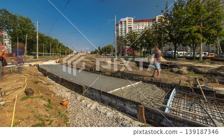 Pouring concrete for road construction with many workers and mixer timelapse Pouring concrete for road construction with many workers and mixer timelapse 139187346