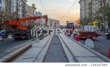 Orange construction telescopic mobile crane unloading tram rails from truck timelapse. Orange construction telescopic mobile crane unloading tram rails from truck timelapse. 139187364