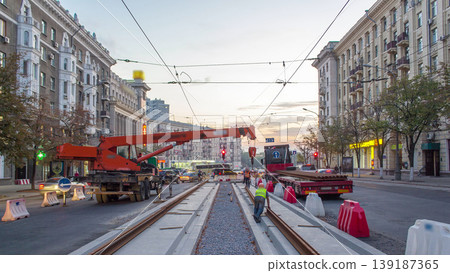 Orange construction telescopic mobile crane unloading tram rails from truck timelapse. Orange construction telescopic mobile crane unloading tram rails from truck timelapse. 139187365