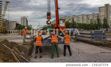 Installing concrete plates by crane at road construction site timelapse. Installing concrete plates by crane at road construction site timelapse. 139187374