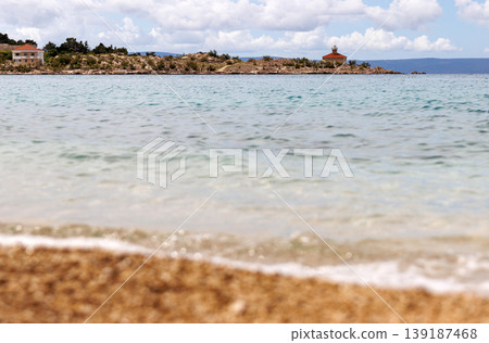 Calm sea water with rocky breakwater and lighthouse at Adriatic sea coast in Makarska, Croatia. Coastal seascape with copy space. Selective focus Calm sea water with rocky breakwater and lighthouse at Adriatic sea coast in Makarska, Croatia. Coastal seascape with copy space. Selective focus 139187468