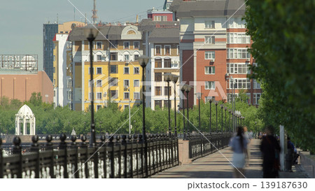 River Ishim, people walk on the waterfront timelapse, buildings, premises, walkway and trees. Sunny day. Astana, Kazakhstan River Ishim, people walk on the waterfront timelapse, buildings, premises, walkway and trees. Sunny day. Astana, Kazakhstan 139187630