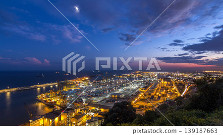 Seaport and loading docks at the port with cranes and multi-colored cargo containers day to night timelapse Seaport and loading docks at the port with cranes and multi-colored cargo containers day to night timelapse 139187663