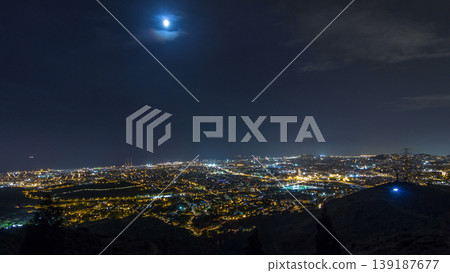 Barcelona and Badalona skyline with roofs of houses and sea on the horizon night timelapse 139187677