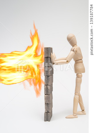 A drawing mannequin supporting a firewall against a blazing flame. 139187784