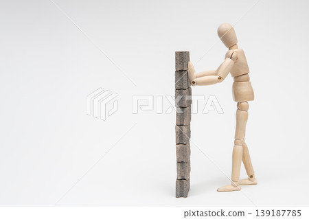 A drawing mannequin supporting a concrete block wall A drawing mannequin supporting a concrete block wall 139187785