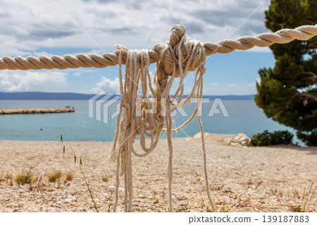 Nautical rope closeup with a blurred seaside background with copy space 139187883