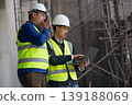 Construction site workers collaborate on project planning urban location business environment professional viewpoint teamwork concept 139188069