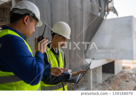 Construction workers collaborate on site urban construction zone engineering process daytime close-up teamwork in action Construction workers collaborate on site urban construction zone engineering process daytime close-up teamwork in action 139188070