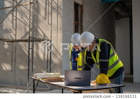 Construction team collaborating on project plans in urban setting professional environment overhead view teamwork concept Construction team collaborating on project plans in urban setting professional environment overhead view teamwork concept 139188131