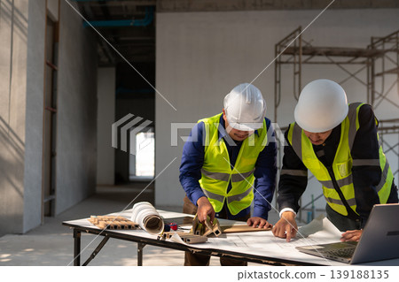 Construction team collaborating on project plans at a building site office environment professional perspective for efficiency Construction team collaborating on project plans at a building site office environment professional perspective for efficiency 139188135