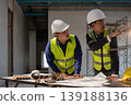 Construction workers collaborating on project plans in urban building site detailed planning professional environment close-up view 139188136