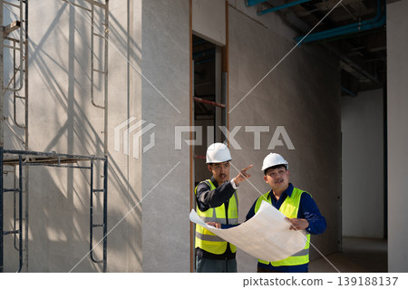 Construction site meeting between engineers urban location professional interaction indoor setting collaborative viewpoint project planning Construction site meeting between engineers urban location professional interaction indoor setting collaborative viewpoint project planning 139188137