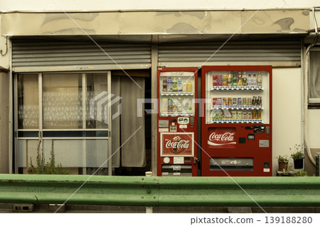 Old Japanese shops and red vending machines create a retro streetscape that evokes the Showa era. Old Japanese shops and red vending machines create a retro streetscape that evokes the Showa era. 139188280